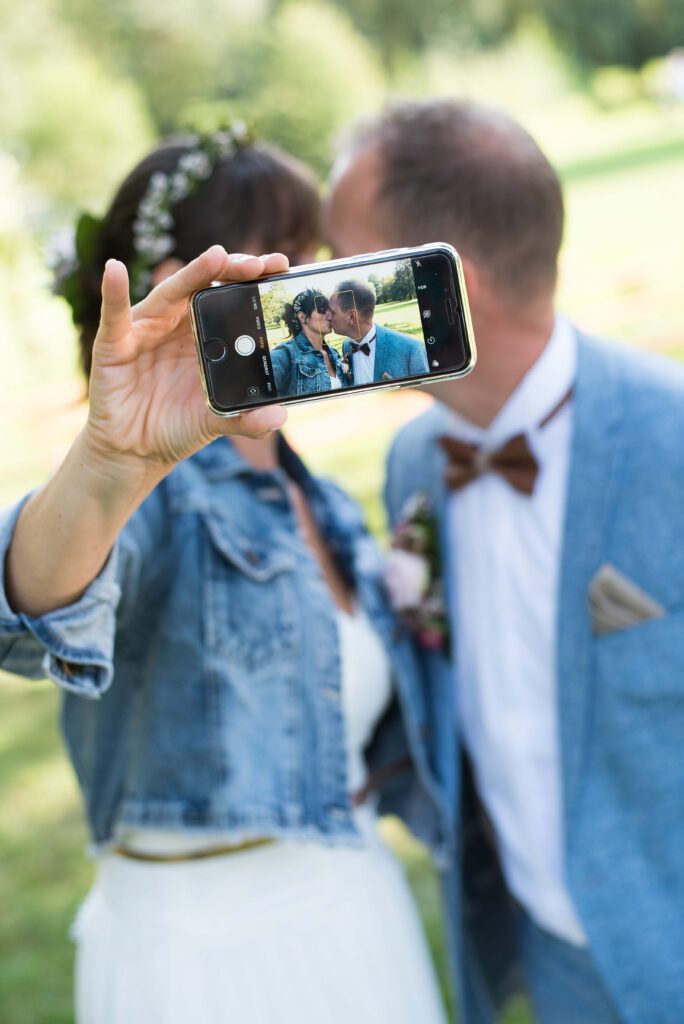 Brautpaar macht Selfie mit Handy, von Stark wie Zwei Hochzeitsfotografie